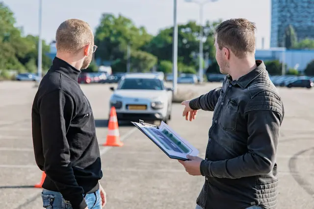 Trafikklærer med elev ved bilen